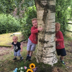 Clare's sons hugging Harry's memorial tree.