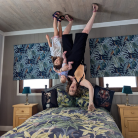 Lucy and her children in an upside down room fun house, so it appears they are standing on the ceiling!