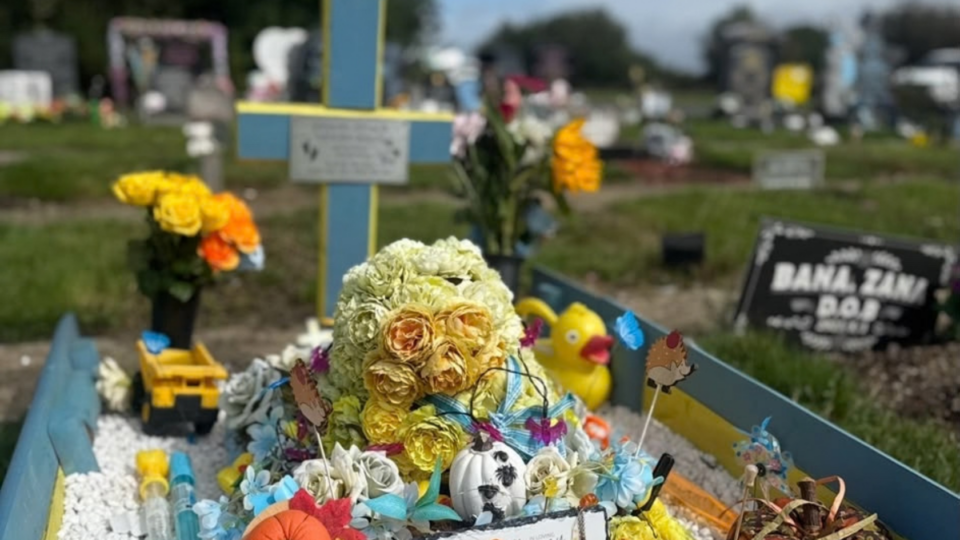 Samuel's grave on halloween. THere are flowers, pumpkins and ducks on his grave.