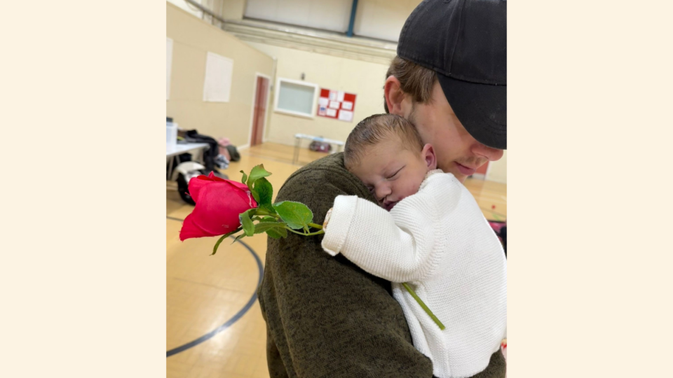 Ben holding Magnolia at todder playgroup, she is holding a red rose.