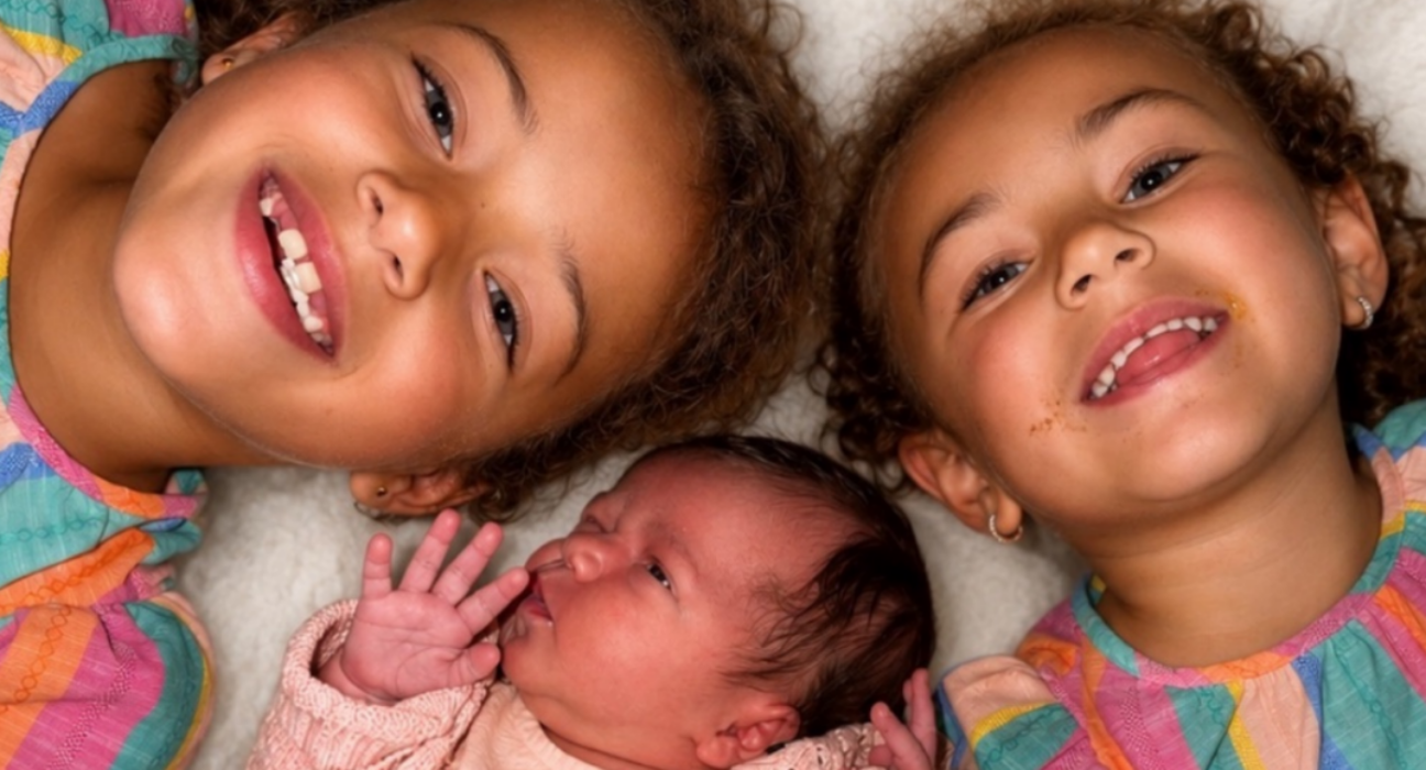 Nevaeh, Niyah and Naleyah, lying down all smiling up at the camera.