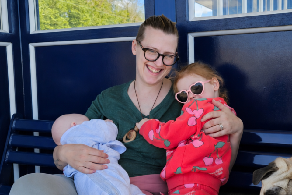 Hebe holding her two children on her lap.