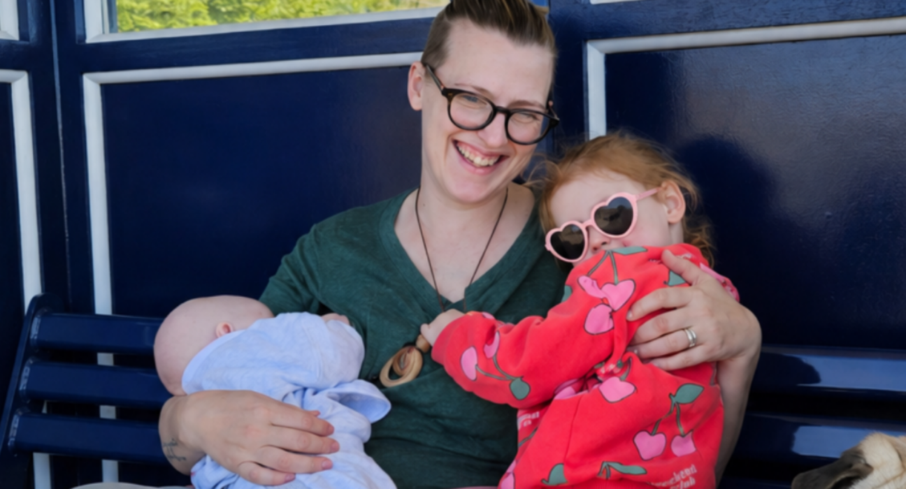 Hebe holding her two children on her lap.