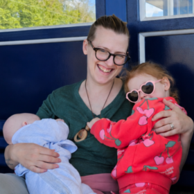 Hebe holding her two children on her lap.