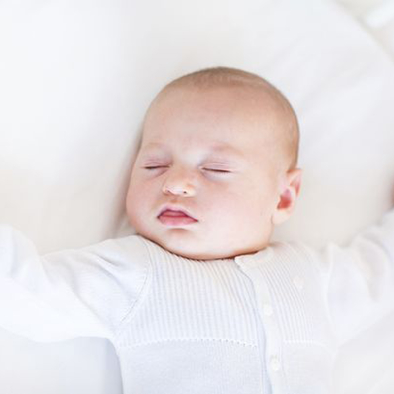 Baby sleeping in a clear cot