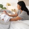mother tending to baby in bedside crib
