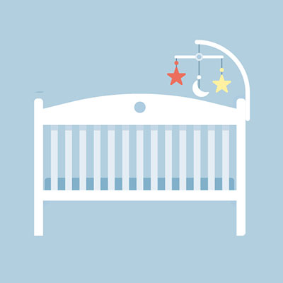 a white cot with a mobile in front of a blue background